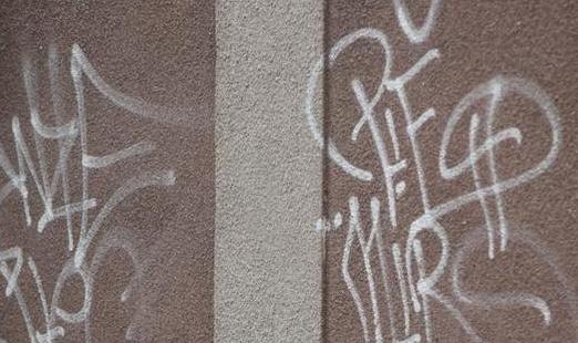 Nepoznati počinitelj ispisao grafite na zgradi škole, metalnom kontejneru i limenoj kućici u Kaptolu